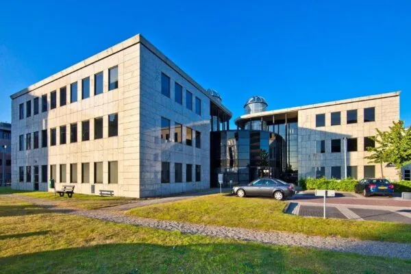 Kantoorgebouw aan de Rivium 1e Straat met moderne architectuur en parkeerplaatsen op de voorgrond.